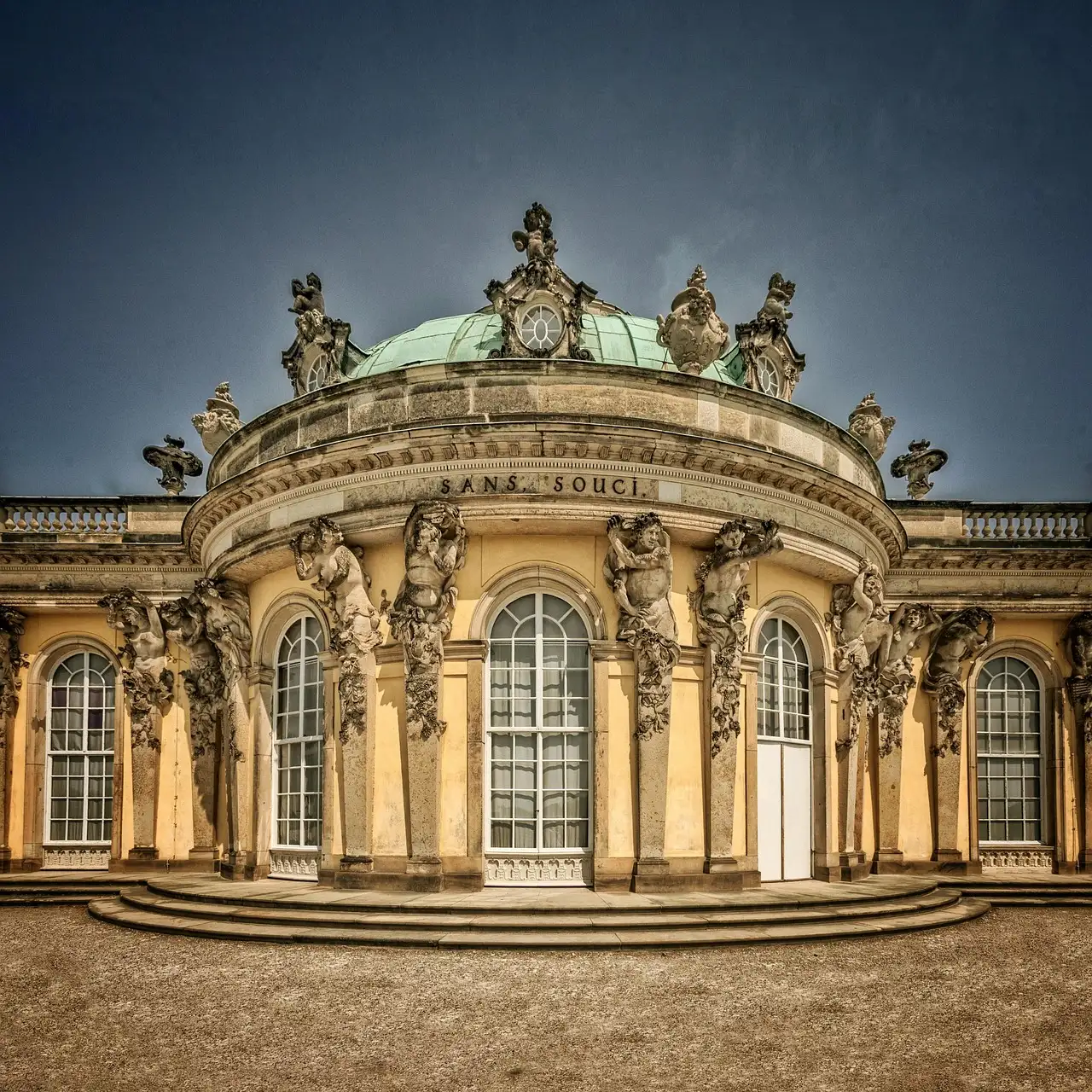 La fachada amarilla del palacio de Sanssouci con su cúpula verde y sus estatuas