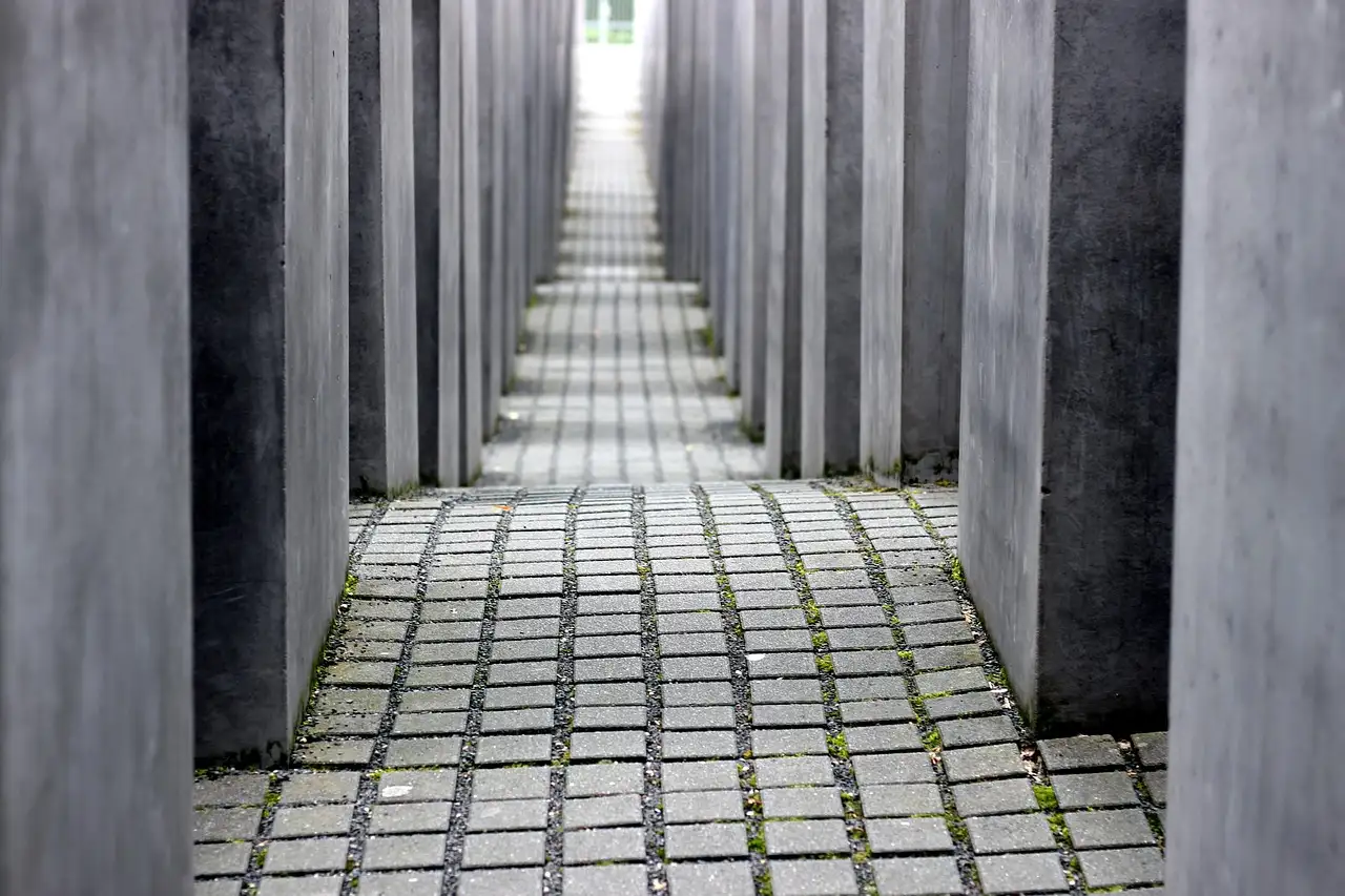 Un pasillo estrecho entre altas estelas de hormigón en el Monumento al Holocausto