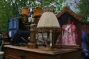Lámparas antiguas y una cómoda a la venta en un puesto de un mercadillo al aire libre