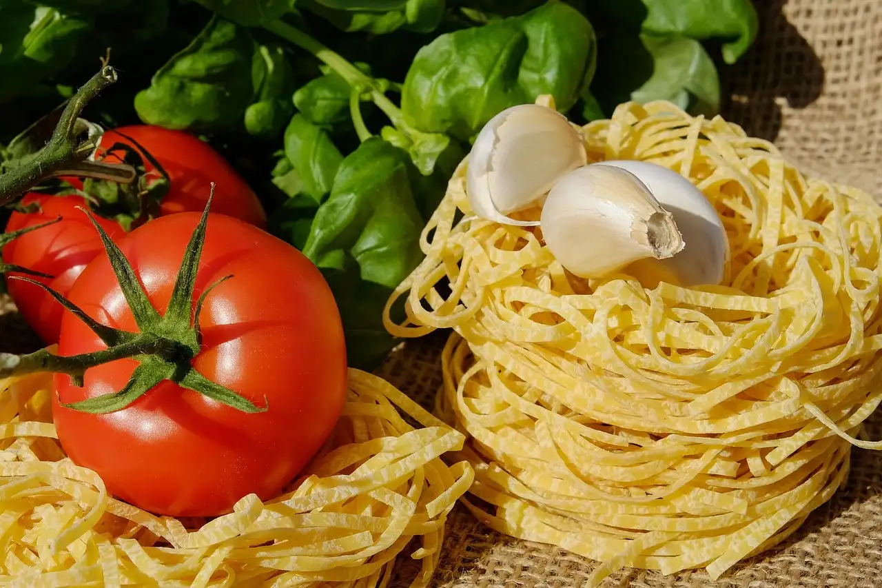Nidos de pasta fresca al huevo junto a tomates maduros, ajo y albahaca