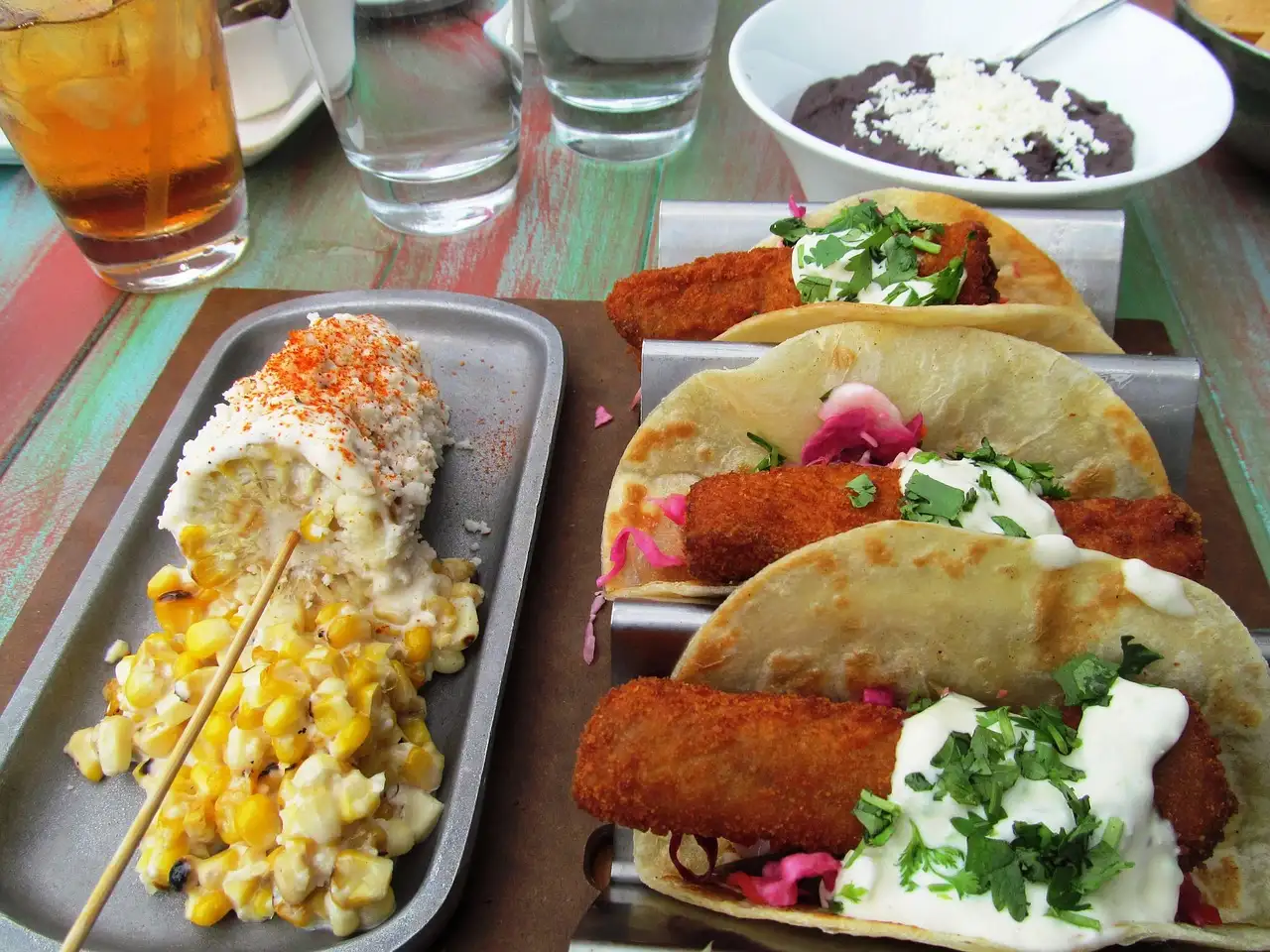Tacos crujientes y maíz a la parrilla en la mesa de un restaurante