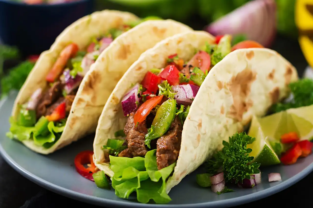 Dos tacos blandos rellenos de carne y verduras frescas