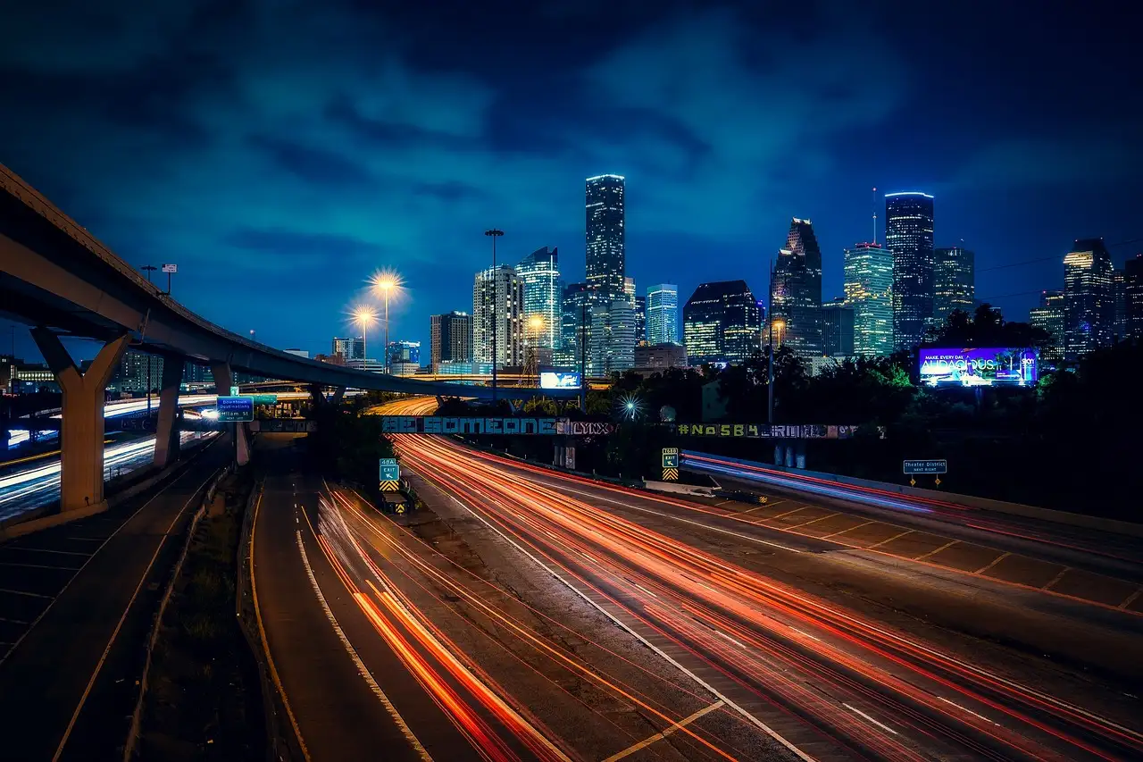 Las torres del centro de Houston iluminadas de noche sobre una autopista