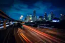 Las torres del centro de Houston iluminadas de noche sobre una autopista