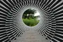 Un anillo de rayas blancas y negras que parece un túnel: una ilusión óptica en un jardín