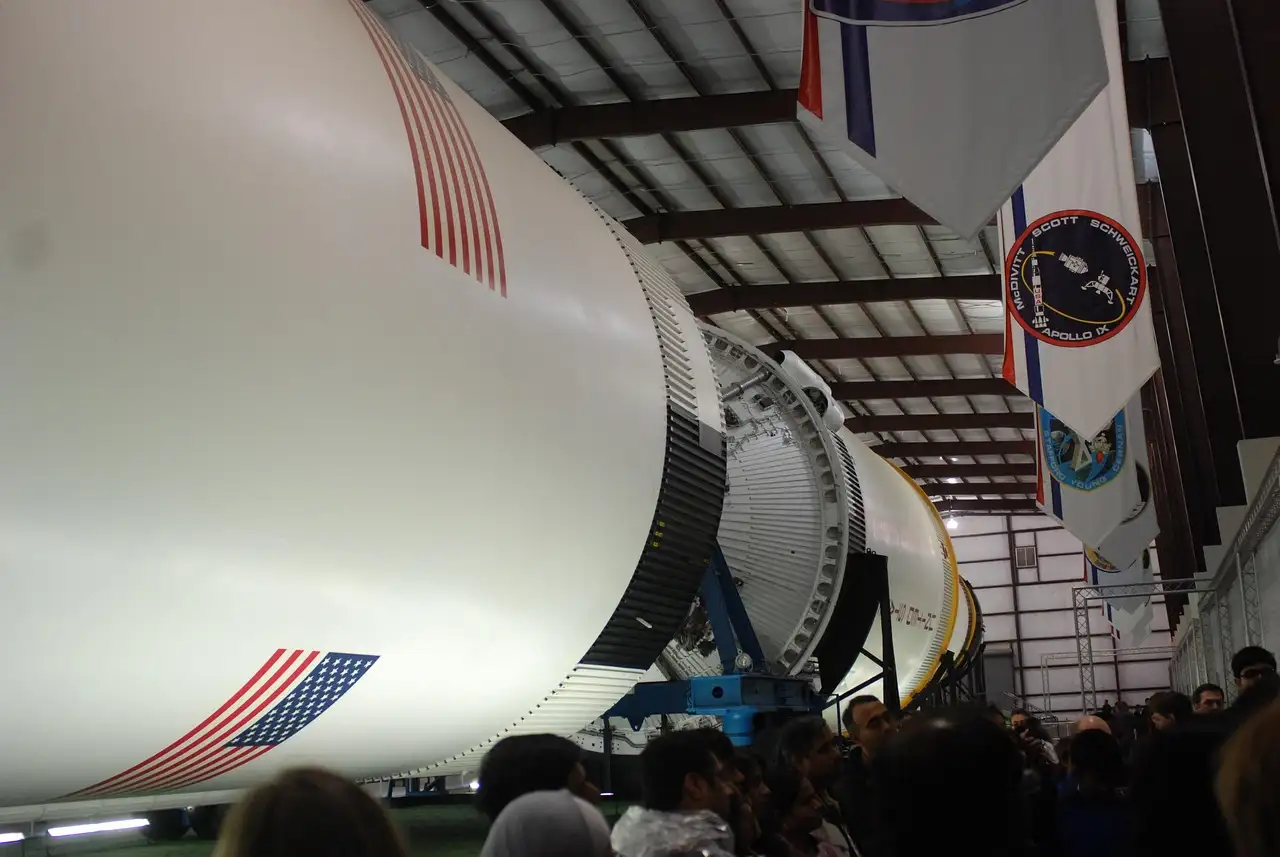 Un cohete Saturn V tumbado en su nave del Space Center Houston, con banderas encima