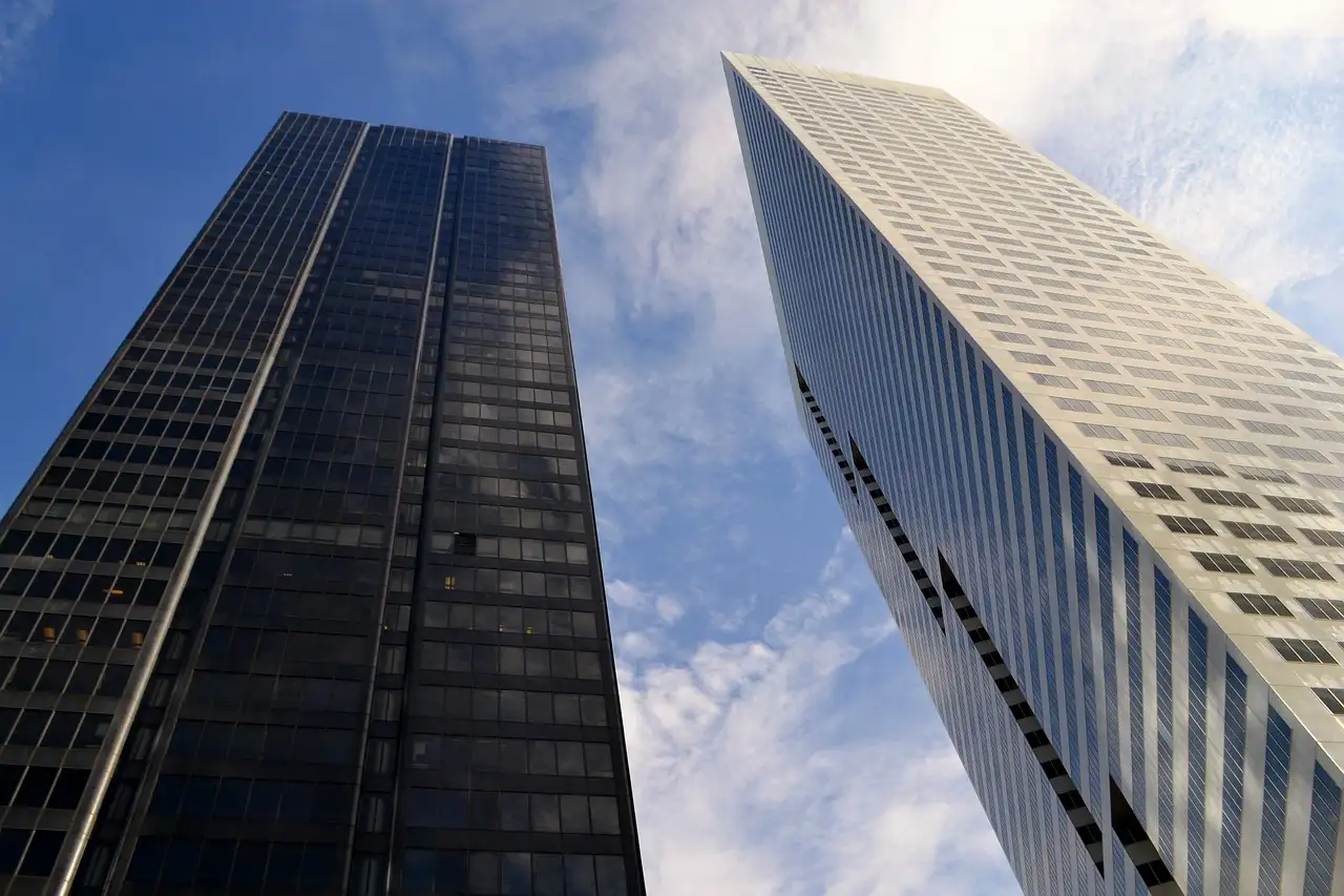 Dos torres de oficinas del centro de Houston vistas desde abajo contra un cielo azul