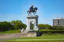 La estatua de Sam Houston a caballo sobre un arco de piedra en el Hermann Park, bajo un cielo azul