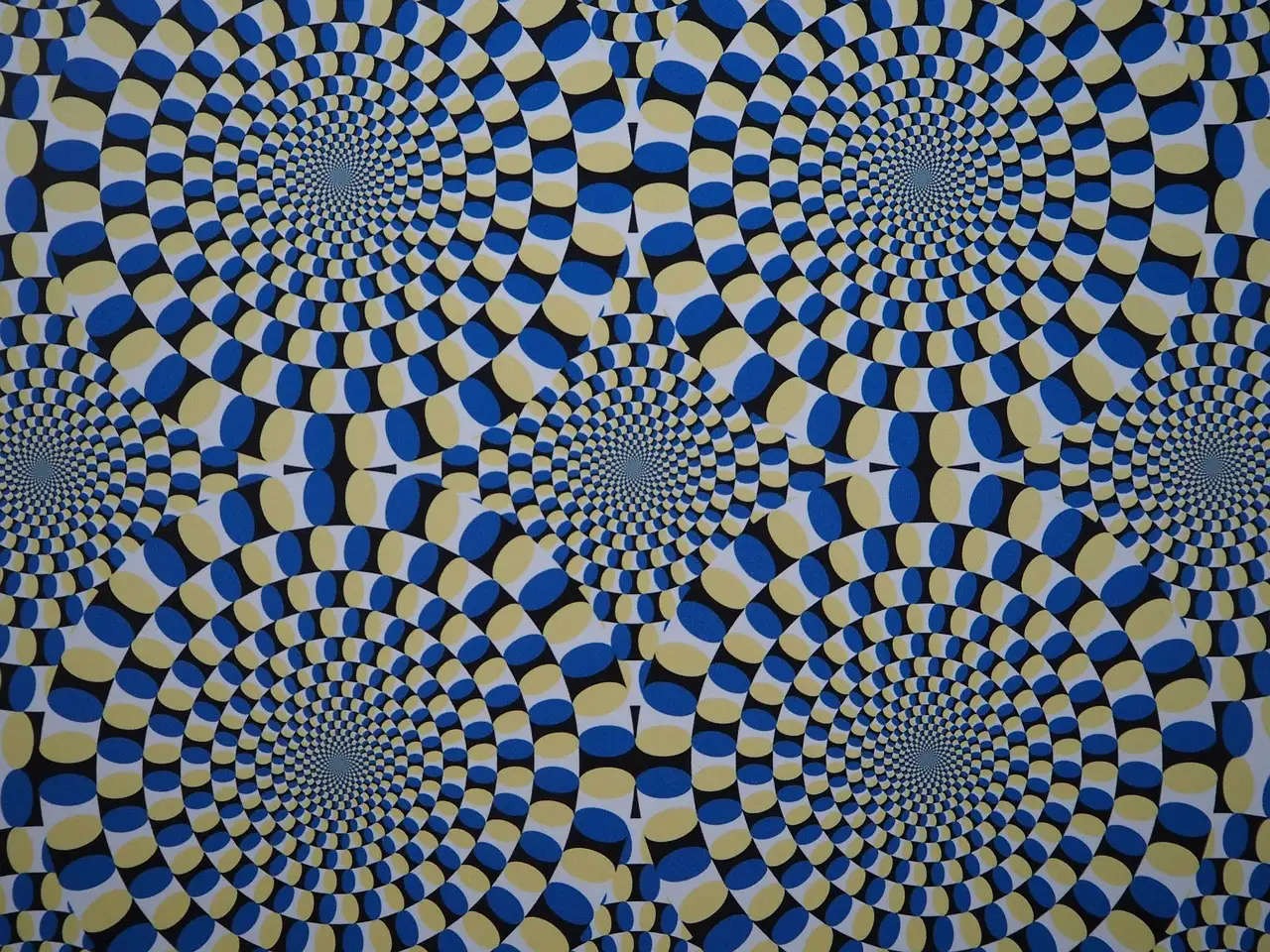 Una ilusión óptica de círculos azules, negros y crema que parecen girar