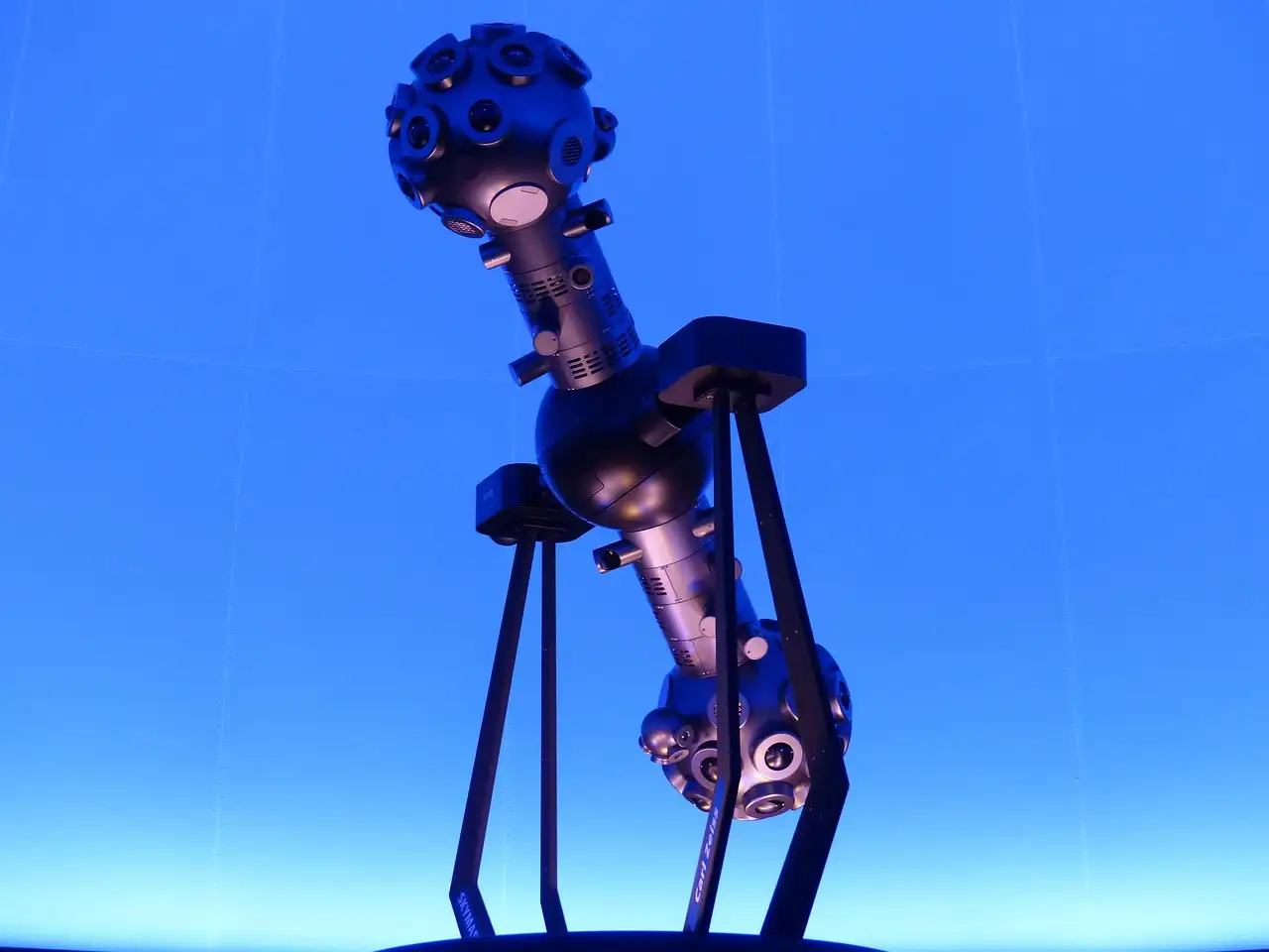Un proyector de estrellas bajo la cúpula azul de un planetario