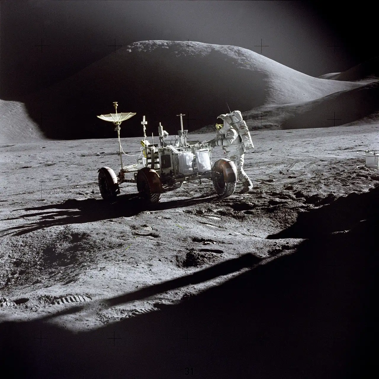 Un astronauta junto al rover lunar sobre la superficie gris de la Luna