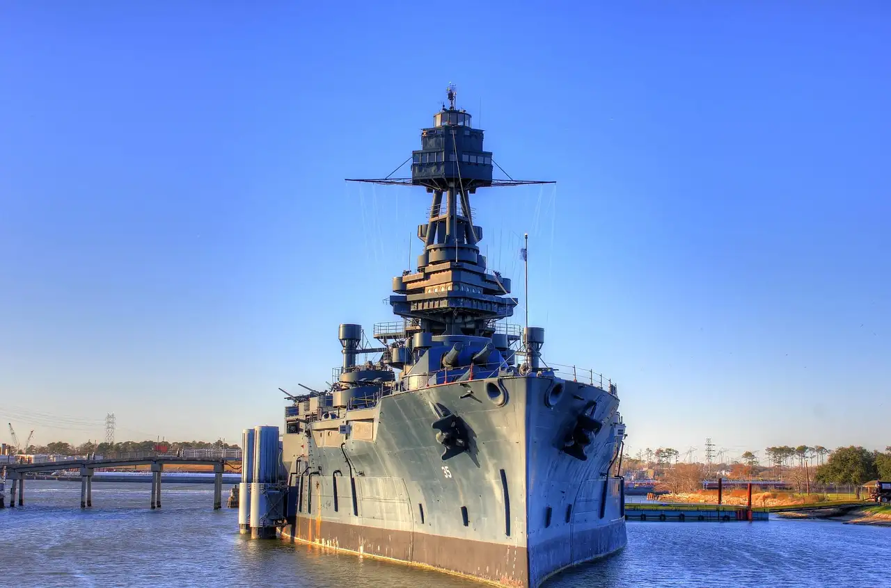 El acorazado Texas en su antiguo amarre cerca de San Jacinto, visto de proa bajo un cielo azul, antes de irse a reparar