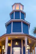 Un faro azul de madera iluminado al anochecer en el paseo marítimo de Kemah, junto a Clear Lake
