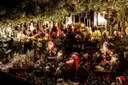 Un puesto de mercado navideño lleno de bolas de cristal y pequeñas figuras de Papá Noel