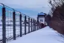 La valla y una torre de vigilancia del memorial de Dachau bajo la nieve