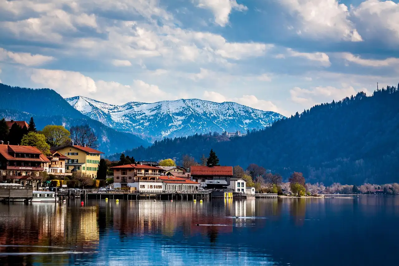 Un pueblo a orillas del lago Tegernsee, con montañas nevadas detrás