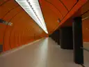 Un andén del U-Bahn de Múnich con paredes curvas de color naranja