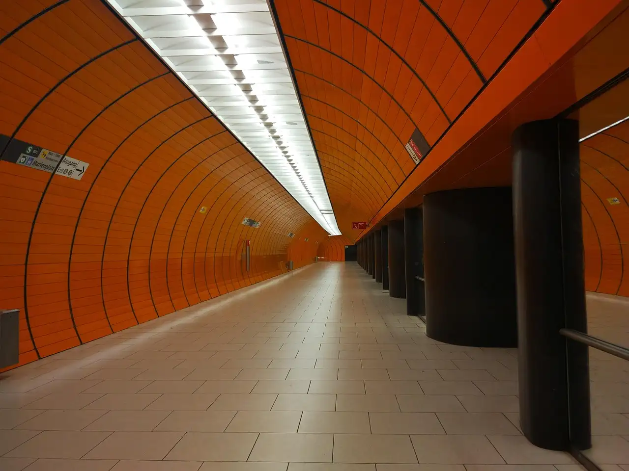 Un andén del U-Bahn de Múnich con paredes curvas de color naranja