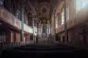 Una capilla barroca en penumbra con un altar dorado, tribunas y filas de bancos