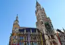 La torre gótica del Nuevo Ayuntamiento en la Marienplatz, vista desde abajo contra un cielo azul