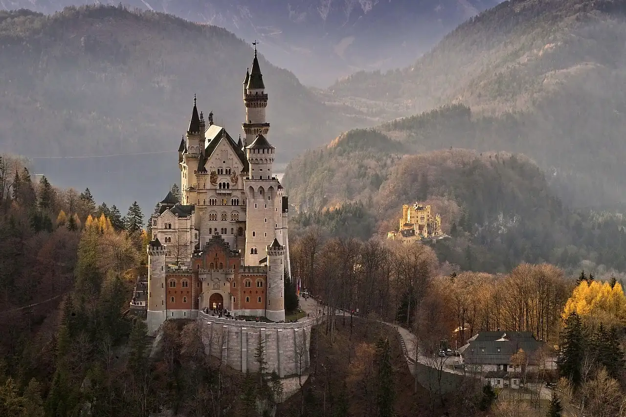 El castillo de Neuschwanstein en otoño, con el castillo de Hohenschwangau y las montañas detrás