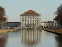 La fachada del Palacio de Nymphenburg reflejada en el canal en calma