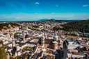 Tejados y cúpulas del casco antiguo de Salzburgo desde arriba, con colinas detrás
