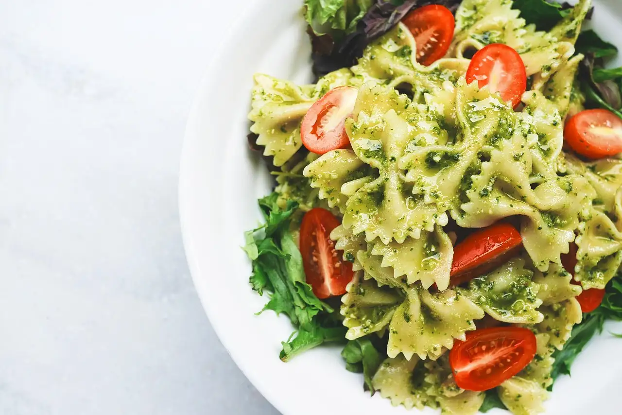 Un plato de pasta al pesto con tomates cherry