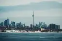 La Torre CN y el centro de Toronto vistos al otro lado del lago Ontario en un día de invierno, con nieve en la orilla