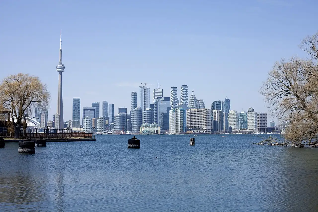 El centro de Toronto y la Torre CN al otro lado del puerto, vistos desde una orilla con sauces sin hojas
