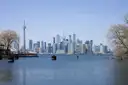 El centro de Toronto y la Torre CN al otro lado del puerto, vistos desde una orilla con sauces sin hojas
