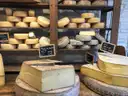 Ruedas de queso en estantes de madera de una quesería