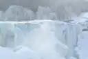 Las cataratas Americanas medio heladas en invierno, con árboles escarchados detrás
