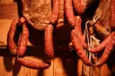 Salchichas ahumadas colgadas en el mostrador de una charcutería