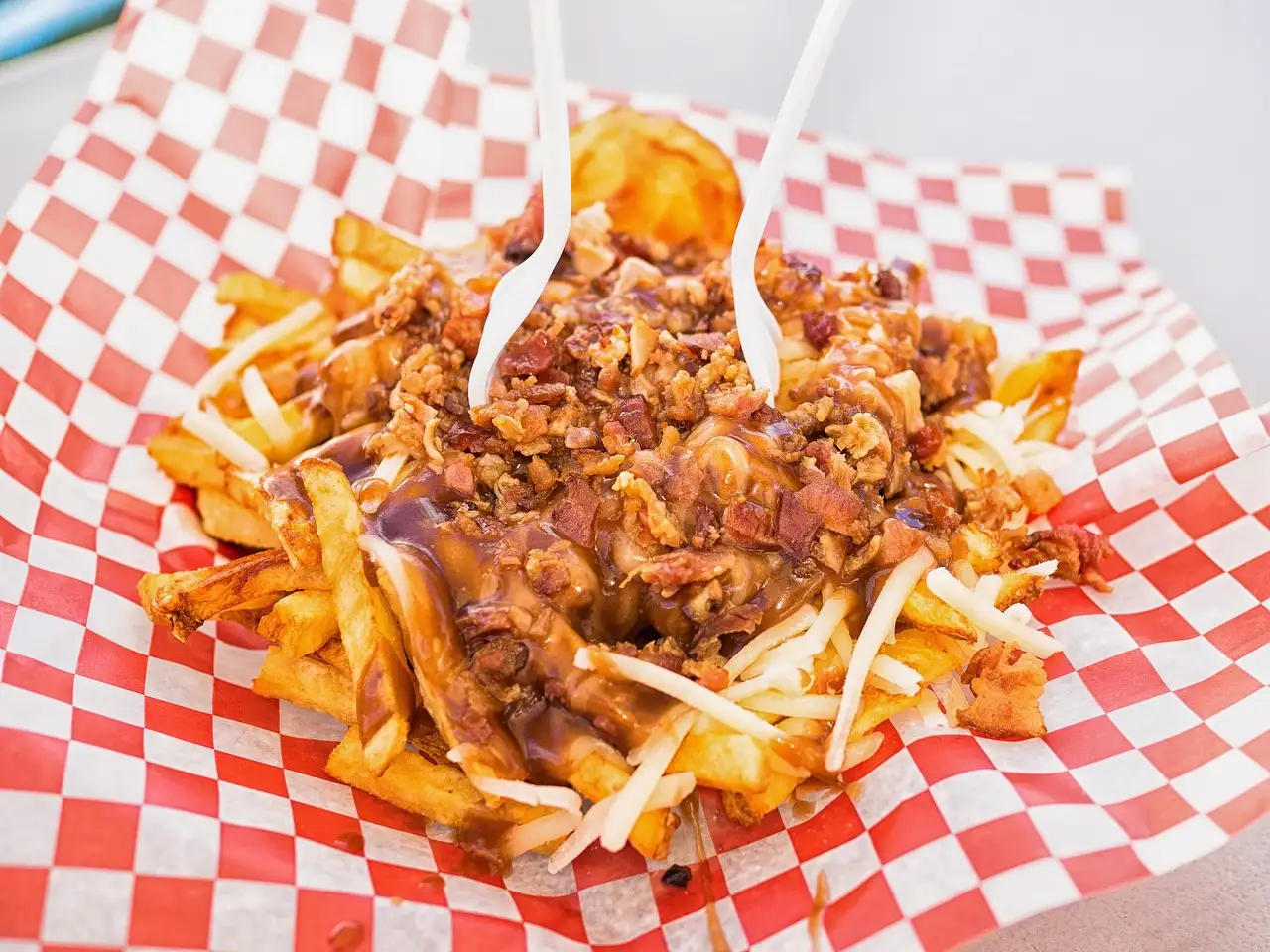 Una bandeja de poutine: patatas fritas con salsa gravy, cuajada de queso y beicon