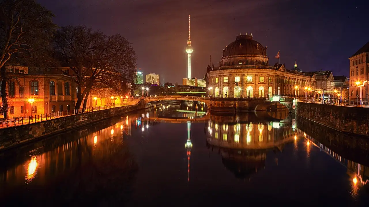 Bode Museum on Museum Island lit up at night, with the TV tower reflected in the Spree