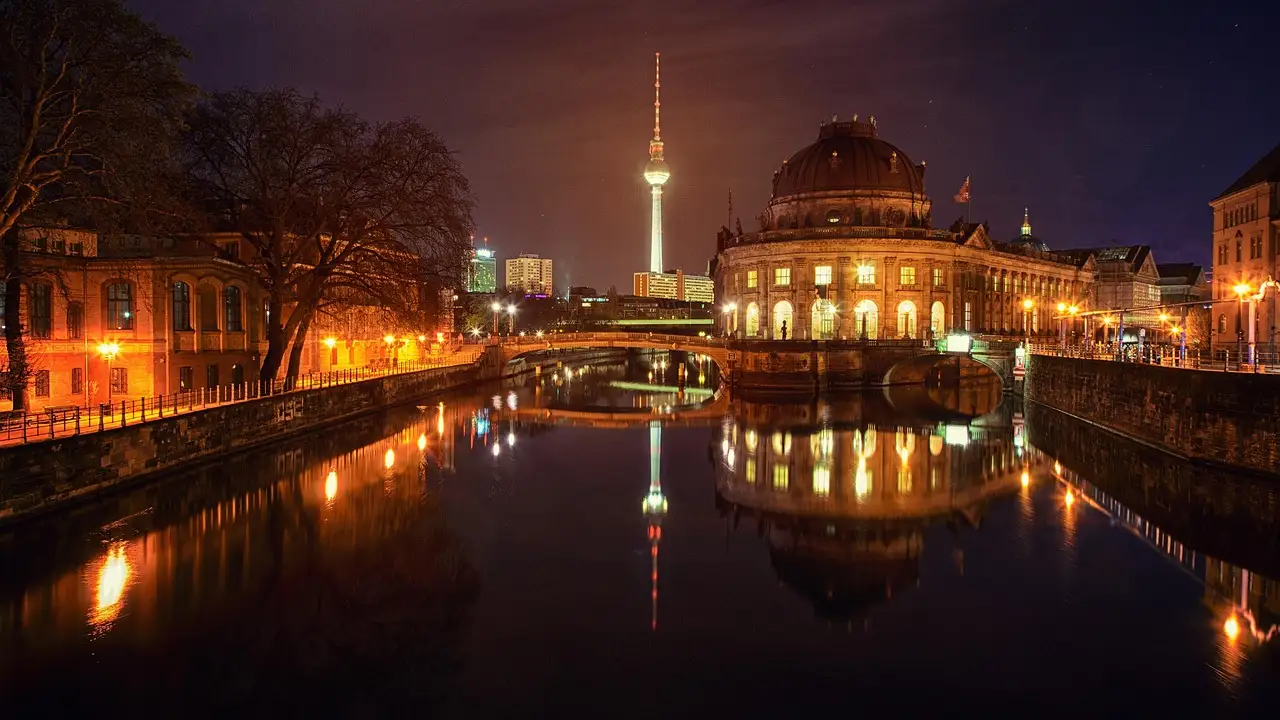 Bode Museum on Museum Island lit up at night, with the TV tower reflected in the Spree