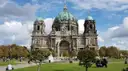 Berlin Cathedral with its green domes behind the lawns of the Lustgarten on a sunny day with clouds