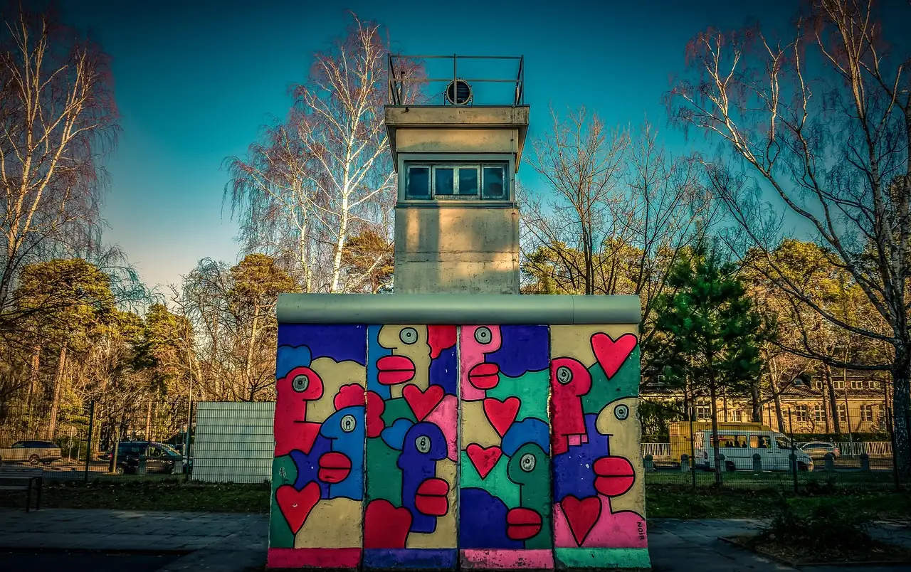 A former border watchtower behind brightly painted Berlin Wall segments