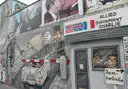 A street mural of Checkpoint Charlie with its Allied sign and passport control