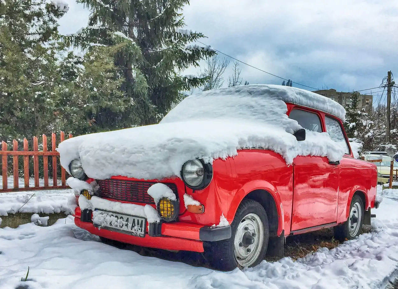 A red Trabant car under fresh snow