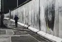 A long surviving stretch of the Berlin Wall beside a pavement