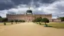 The New Palace in Potsdam at the end of a wide gravel path lined with trees
