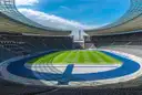 Inside the empty Berlin Olympic Stadium with its green pitch, blue running track and curved roof