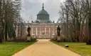 The New Palace in Potsdam at the end of a tree-lined avenue with statues