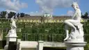 A white marble statue in front of the terraces and Sanssouci Palace