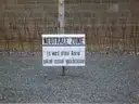 A 'neutral zone' warning sign before the barbed wire and camp wall at Sachsenhausen