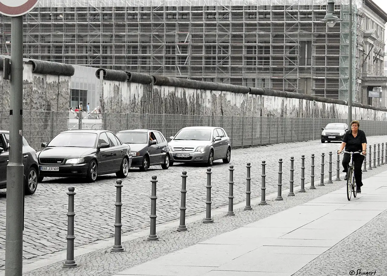 A cyclist riding past a surviving stretch of the Berlin Wall