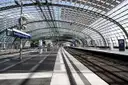 Empty platform under the curved glass roof of Berlin Hauptbahnhof with the station name sign