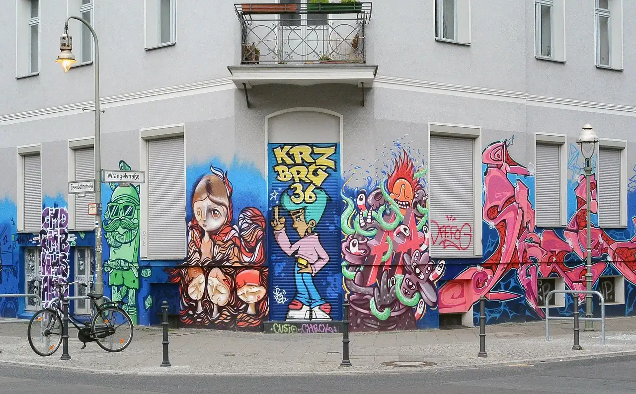 Colorful street art murals on a corner building in Kreuzberg, with a bicycle in front